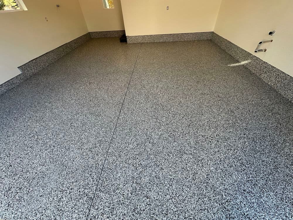 Newly installed flake epoxy garage floor with a smooth finish and neutral color.